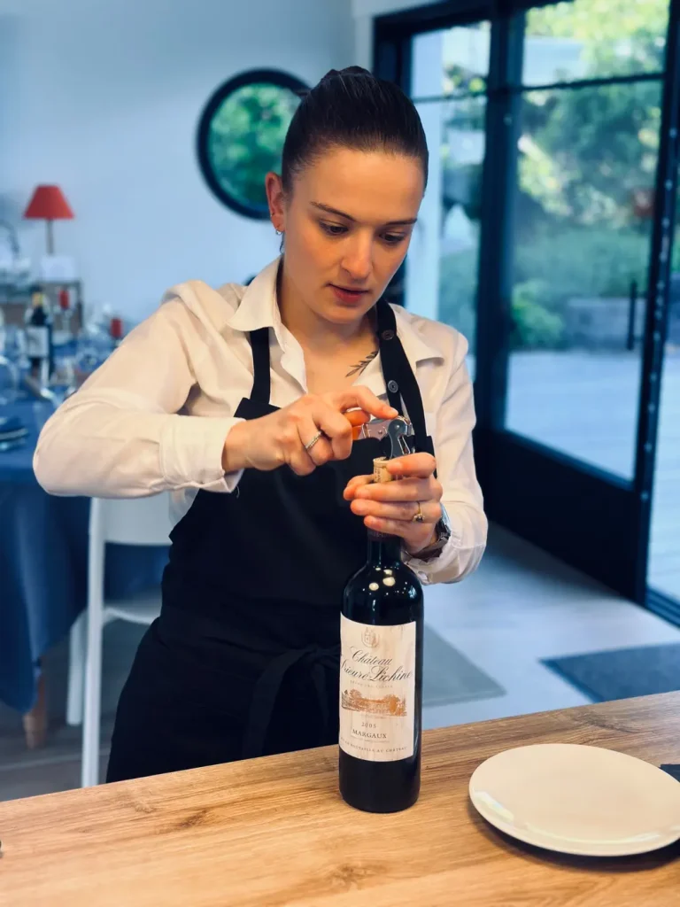 Agathe Pagès, maître d’hôtel et sommelière, ouvrant une bouteille de vin